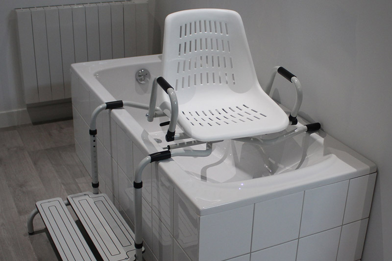 Siège de douche avec accoudoirs et marchepied intégré